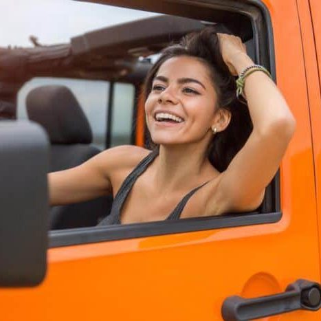Happy cheerful woman driving a car