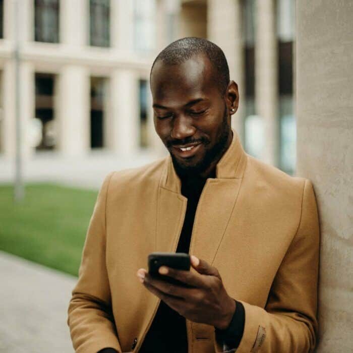 selective-focus-photo-of-smiling-man-looking-at-his-phone-3206080-scaled-square